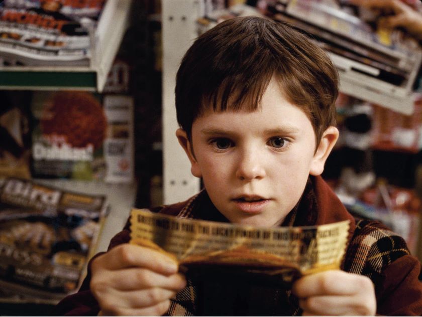 Charlie and the Chocolate Factory Picture 13, Movie shot of Freddie Highmore as Charlie, holding the Golden Ticket.