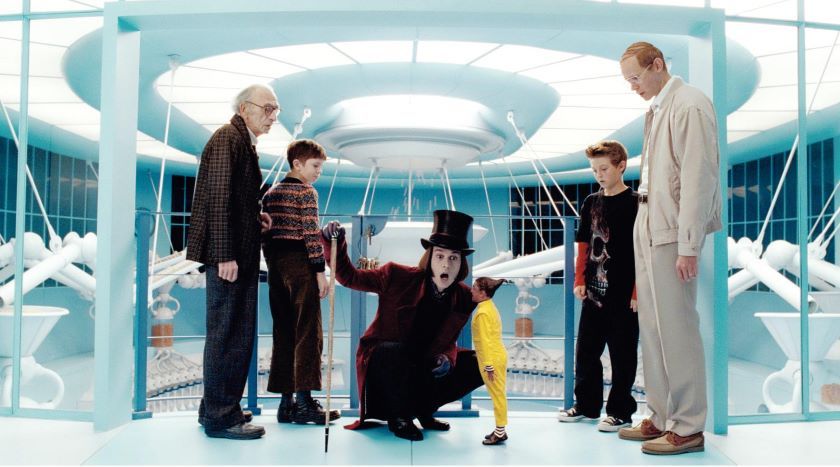Charlie and the Chocolate Factory Picture, Movie full shot of Johnny Depp as Willy Wonka crouching down to talk to Deep Roy as Oompa-Loompa while David Kelly as Grandpa Joe, Freddie Highmore as Charlie, Jordan Fry as Mike Teavee and Adam godley as Mr. Teavee look on.